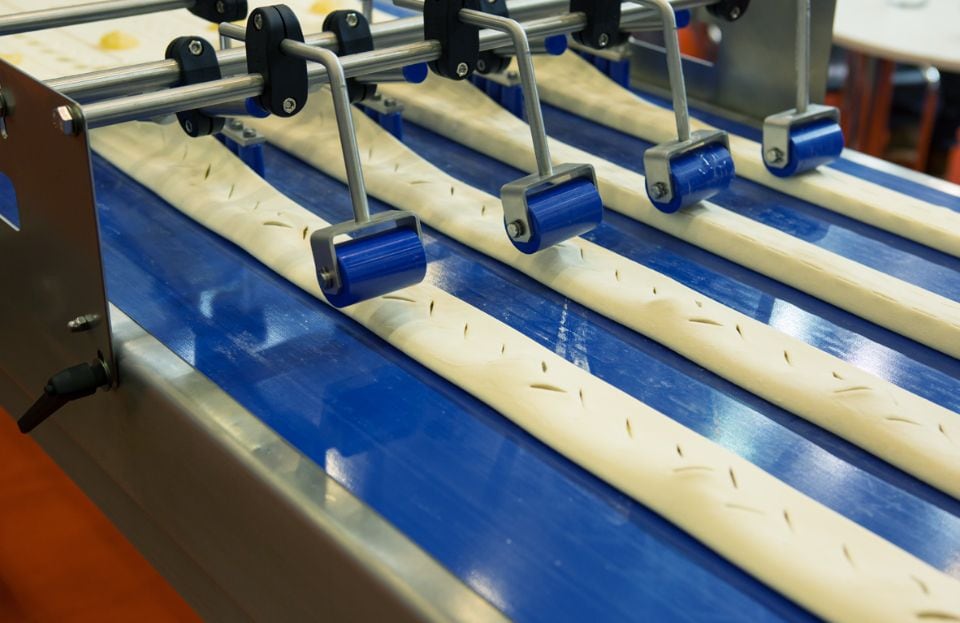 Blue plastics on a conveyor belt in an industrial baking facility